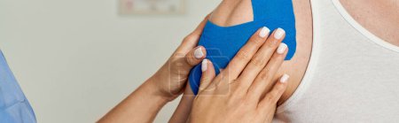 Photo for Cropped view of hand of young doctor putting kinesiological tape on shoulder of her patient, banner - Royalty Free Image