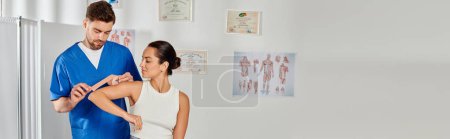 Foto de Hermosa mujer en traje casual mirando a su médico poniendo cinta de kinesio en el codo, pancarta - Imagen libre de derechos