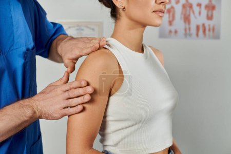 Photo for Cropped view of doctor checking muscles of his young female patient during appointment, healthcare - Royalty Free Image