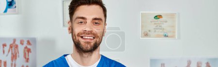 Photo for Jolly good looking doctor with beard posing and smiling happily at camera, healthcare, banner - Royalty Free Image