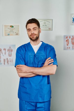 Photo for Good looking bearded doctor with arms crossed on chest looking straight at camera, healthcare - Royalty Free Image