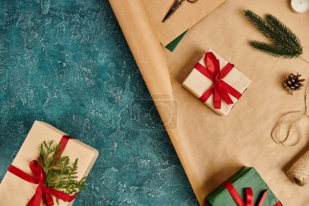 fournitures de décoration bricolage près de boîtes-cadeaux avec des rubans rouges sur la surface texturée bleue, fond de Noël