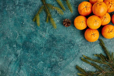 Téléchargez les photos : Mandarines mûres et branches de sapin avec cône de pin sur fond texturé bleu avec espace de copie - en image libre de droit