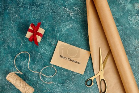 enveloppe avec Joyeux v?ux de Noël près de la boîte cadeau et des fournitures de décoration sur bleu, artisanat de vacances