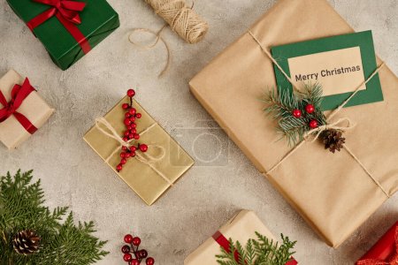 telón de fondo festivo, tarjeta de felicitación Feliz Navidad cerca de cajas de regalo con ramas de pino y bayas de acebo