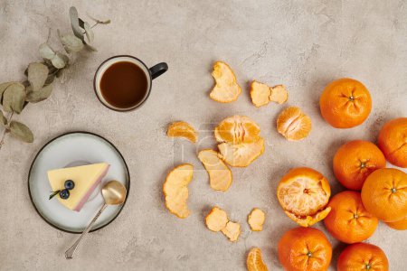 ripe tangerines and traditional hot chocolate drink and Christmas pudding on grey textured surface