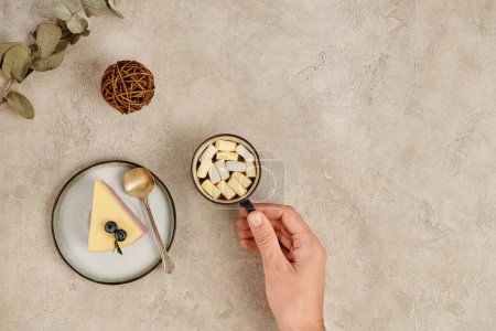Photo for Cropped view of woman with mug of hot chocolate with marshmallows near sweet Christmas pudding - Royalty Free Image