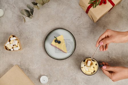 Téléchargez les photos : Vue partielle de la femme avec cuillère à thé près de chocolat chaud avec guimauves et pudding de Noël - en image libre de droit