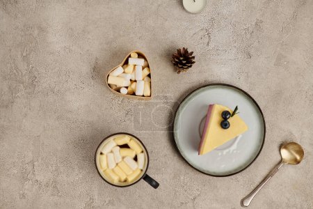 chocolat chaud avec guimauves et pudding de Noël aux myrtilles près du cône de pin sur gris
