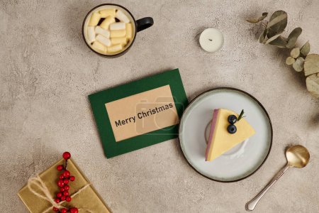 Feliz Navidad tarjeta de felicitación cerca de pudín y chocolate caliente con malvavisco, golosinas de Navidad
