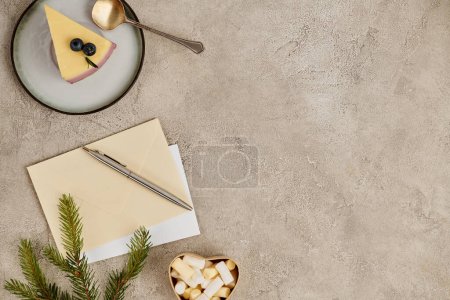 Tema navideño, poste sobres y bolígrafo cerca de pudín y chocolate caliente con malvaviscos en gris