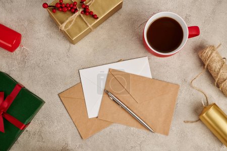 Téléchargez les photos : Chocolat chaud près des enveloppes et boîtes cadeaux avec des bougies sur fond gris texturé, Noël - en image libre de droit