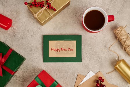 Photo for Happy new year greeting card near decorated gift boxes and mug of hot chocolate on textured surface - Royalty Free Image