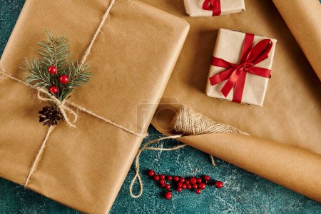 Téléchargez les photos : Coffrets cadeaux avec rubans rouges et branches de pin avec des baies de houx sur papier artisanal, thème de Noël - en image libre de droit