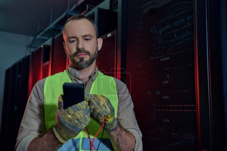 Photo for Handsome bearded technician in safety clothes and gloves holding detector during inspection - Royalty Free Image