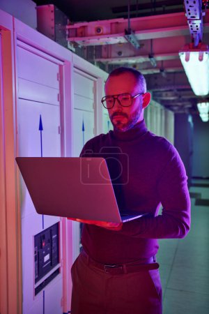 Photo for Concentrated good looking data center specialist in turtleneck working on his laptop attentively - Royalty Free Image