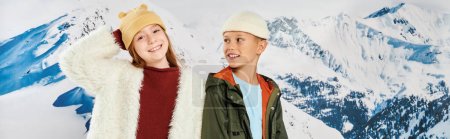 Kleiner Junge mit Blick auf süßes Mädchen, beide im Winter stilvolle Outfits glücklich lächelnd, Mode, Banner
