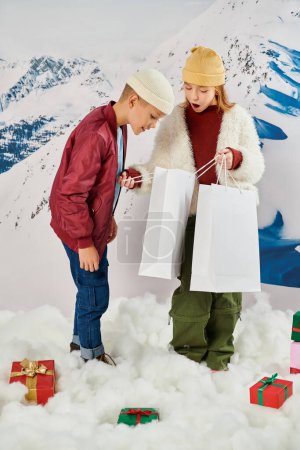 vertikale Aufnahme von kleinen Freunden, die glücklich und aufgeregt in der Geschenktüte schauen, Modekonzept