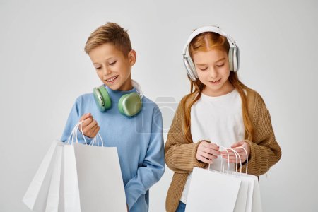 jolly little friends with headphones looking in their present bags, Black Friday, fashion concept