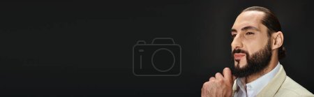 Photo for Handsome bearded arabic man in white shirt and blazer looking away on black backdrop, banner - Royalty Free Image
