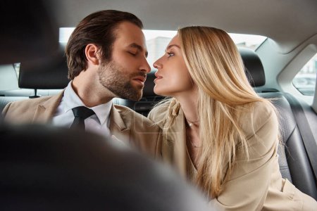 stylish businessman and attractive blonde woman sitting face to face in luxury car, seduction