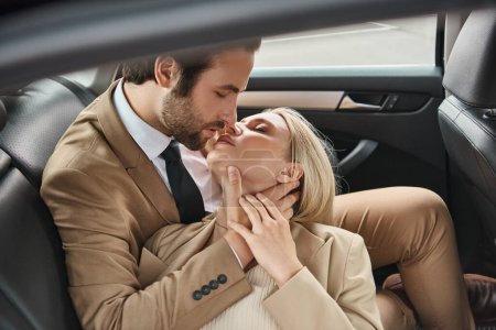 pareja de negocios con estilo y éxito besándose con los ojos cerrados mientras viaja en coche, romance