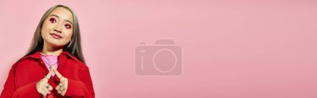 Téléchargez les photos : Heureux jeune asiatique femme avec coeur en forme de maquillage des yeux souriant et regardant loin sur rose, bannière - en image libre de droit