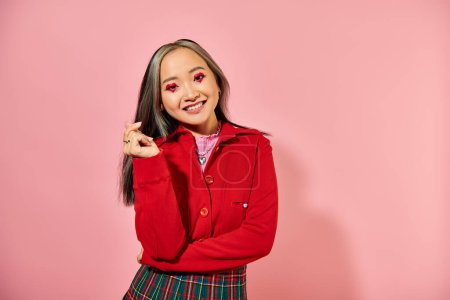 San Valentín día, feliz asiático joven mujer con corazón ojo maquillaje mostrando corazón con los dedos en rosa