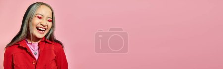 Valentines day banner, happy asian woman with heart eye makeup laughing on pink background