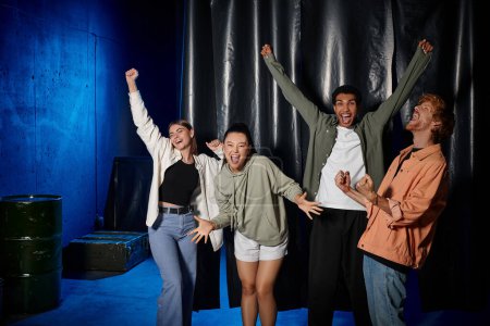 Photo for Group of young multicultural friends celebrating success after solving mystery in escape room - Royalty Free Image