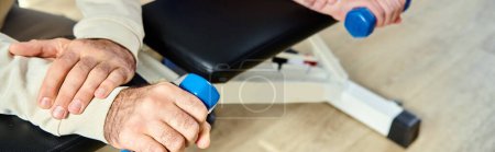 Photo for Cropped view of man working out with dumbbell near recovery specialist in kinesio center, banner - Royalty Free Image