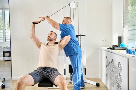 Photo for Young instructor assisting man during recovery training on exercise machine in kinesio center - Royalty Free Image