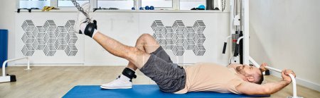 Photo for Side view of man lying down on fitness mat during recovery training in kinesio center, banner - Royalty Free Image