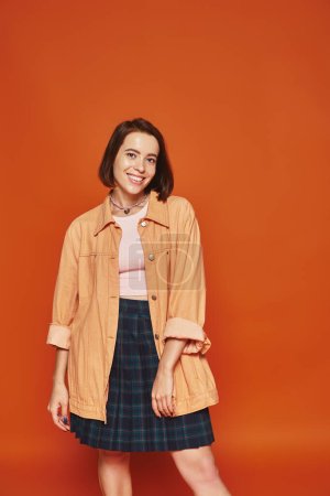 Photo for Excited young woman with short hair looking at camera and smiling on orange background, carefree - Royalty Free Image