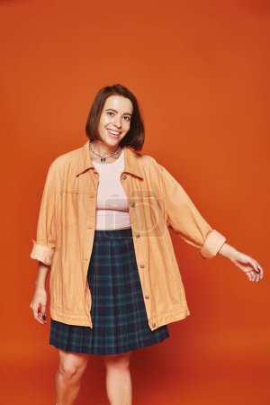 Photo for Cheerful young woman with short hair looking at camera and smiling on orange background, joy - Royalty Free Image