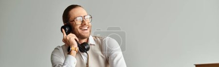 alegre hombre guapo con barba y gafas hablando por teléfono retro y mirando hacia otro lado, pancarta