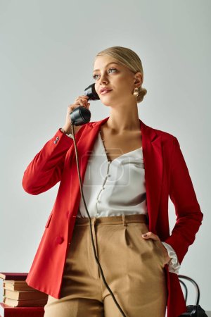 attraktive Frau mit gesammelten Haaren in leuchtend roter Jacke spricht per Retro-Telefon mit der Hand in der Tasche