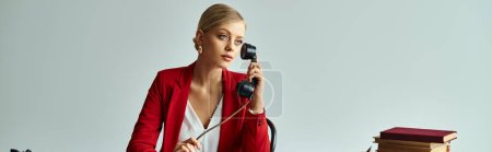 Reizvolle sexy Frau in roter Jacke sitzt am Tisch und telefoniert im Büro mit Retro-Telefon, Banner