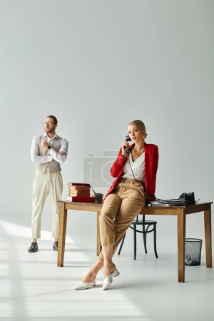 handsome man with arms crossed on chest next to his sexy girlfriend talking by phone, work affair