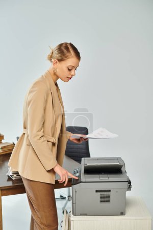 appealing young woman with collected blonde hair using copy machine while working in office