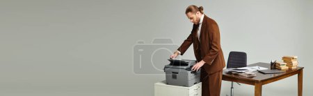 hombre guapo con barba y pelo recogido en chaqueta elegante que trabaja con la máquina de copia, pancarta