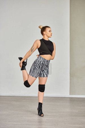 woman gracefully stretches leg in zebra shorts and high heels, displaying balance and flexibility