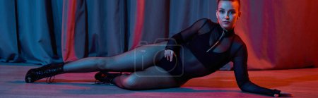 Photo for Banner, graceful woman lays on floor surrounded by a curtain as she showcases her talent for dance - Royalty Free Image