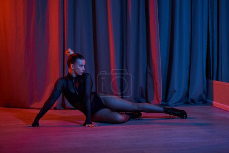 graceful woman lays on floor surrounded by curtain as she showcases her talent for dance