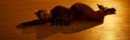 Téléchargez les photos : Bannière de femme met en valeur la grâce dans une pose de danse, ses talons hauts plantés fermement sur le sol - en image libre de droit