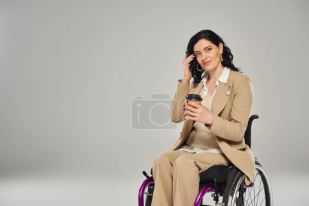 gut aussehende behinderte Frau im Rollstuhl in pastellfarbener eleganter Kleidung, Kaffee haltend, Beeinträchtigung