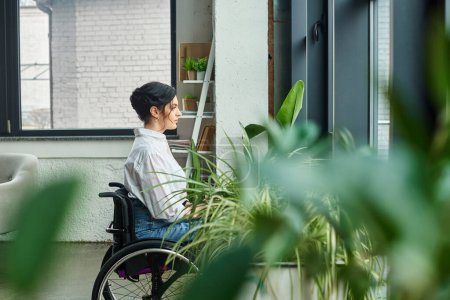 Téléchargez les photos : Belle femme d'affaires handicapée en tenue élégante en fauteuil roulant regardant loin tandis que dans le bureau - en image libre de droit