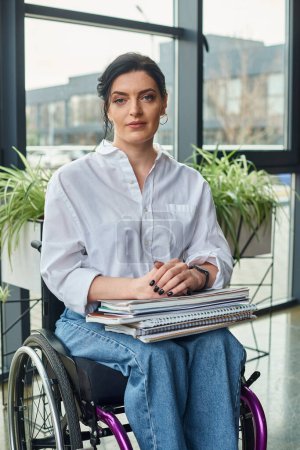 attractive devoted businesswoman in stylish attire in wheelchair looking straight at camera