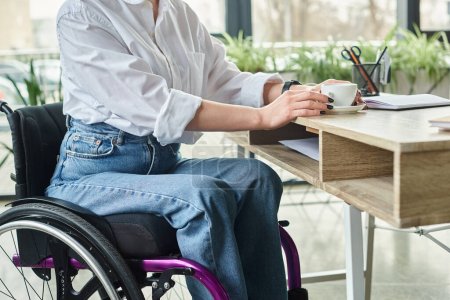 Ausgeschnittene Ansicht einer engagierten Geschäftsfrau mit Behinderung im Rollstuhl, die hart im Büro arbeitet