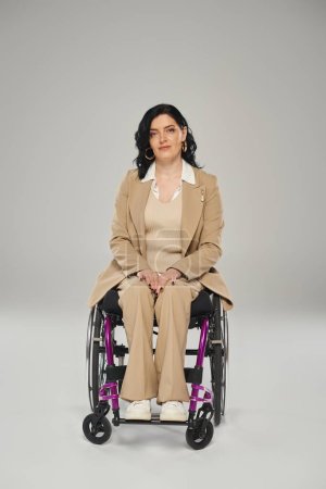 good looking disabled woman in elegant pastel suit in wheelchair looking straight at camera